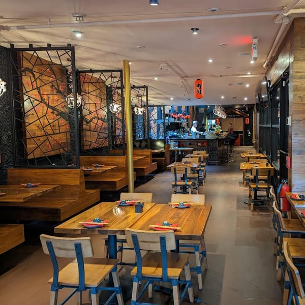 Interior of Akeno Sushi Bar and Thai, showing dining tables, booths, and a sushi bar.
