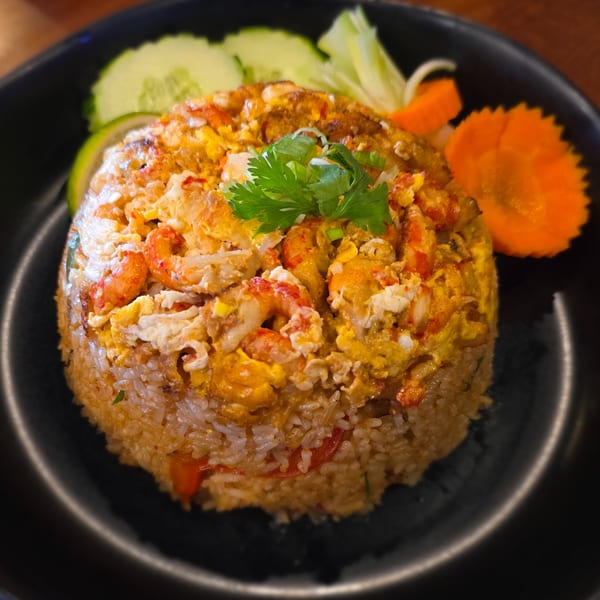 Akeno Sushi Bar and Thai's shrimp fried rice with egg, cilantro, cucumber, and carrot garnish.