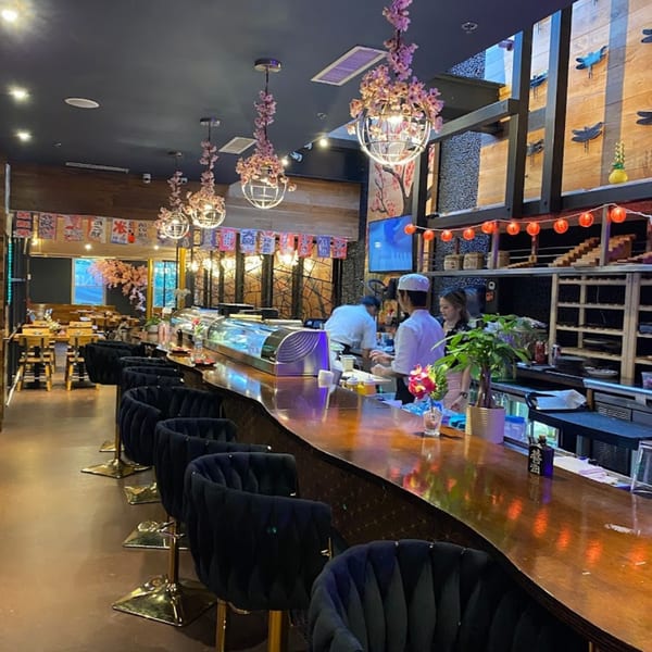 Akeno Sushi Bar and Thai's sushi bar with chefs, black velvet chairs, and cherry blossom decor.