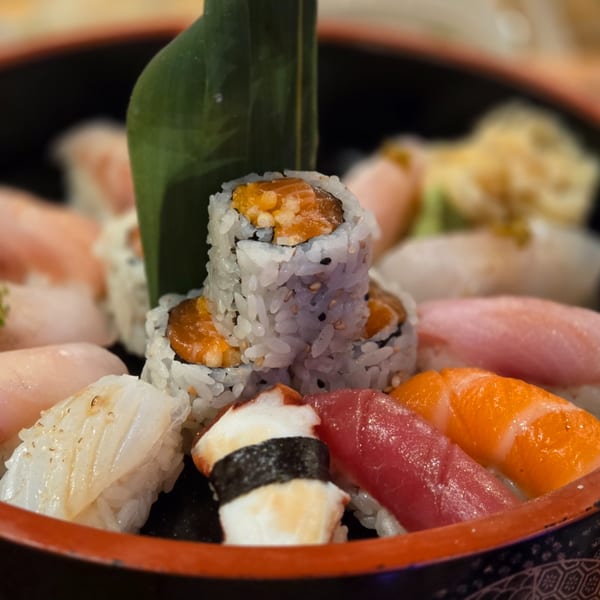 A close-up of a sushi platter with various nigiri and maki rolls, including tuna, salmon, and octopus.
