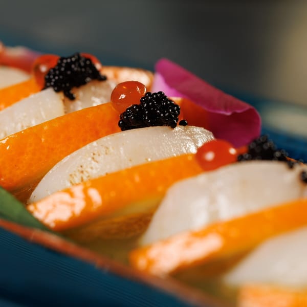 A close-up of Akeno Sushi Bar and Thai's sushi, topped with black caviar and red berries.